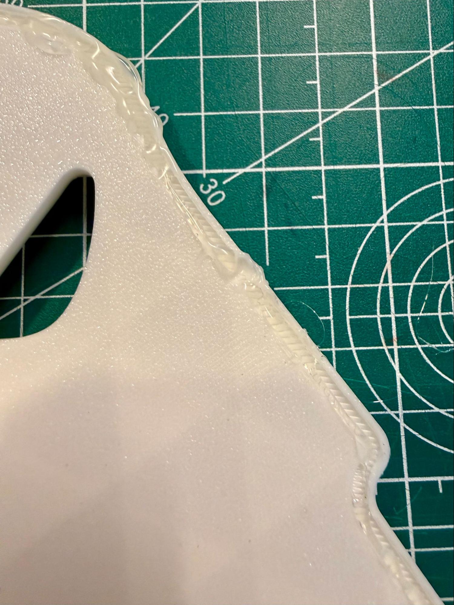 A spot where the glue gun tip deformed the plastic base
